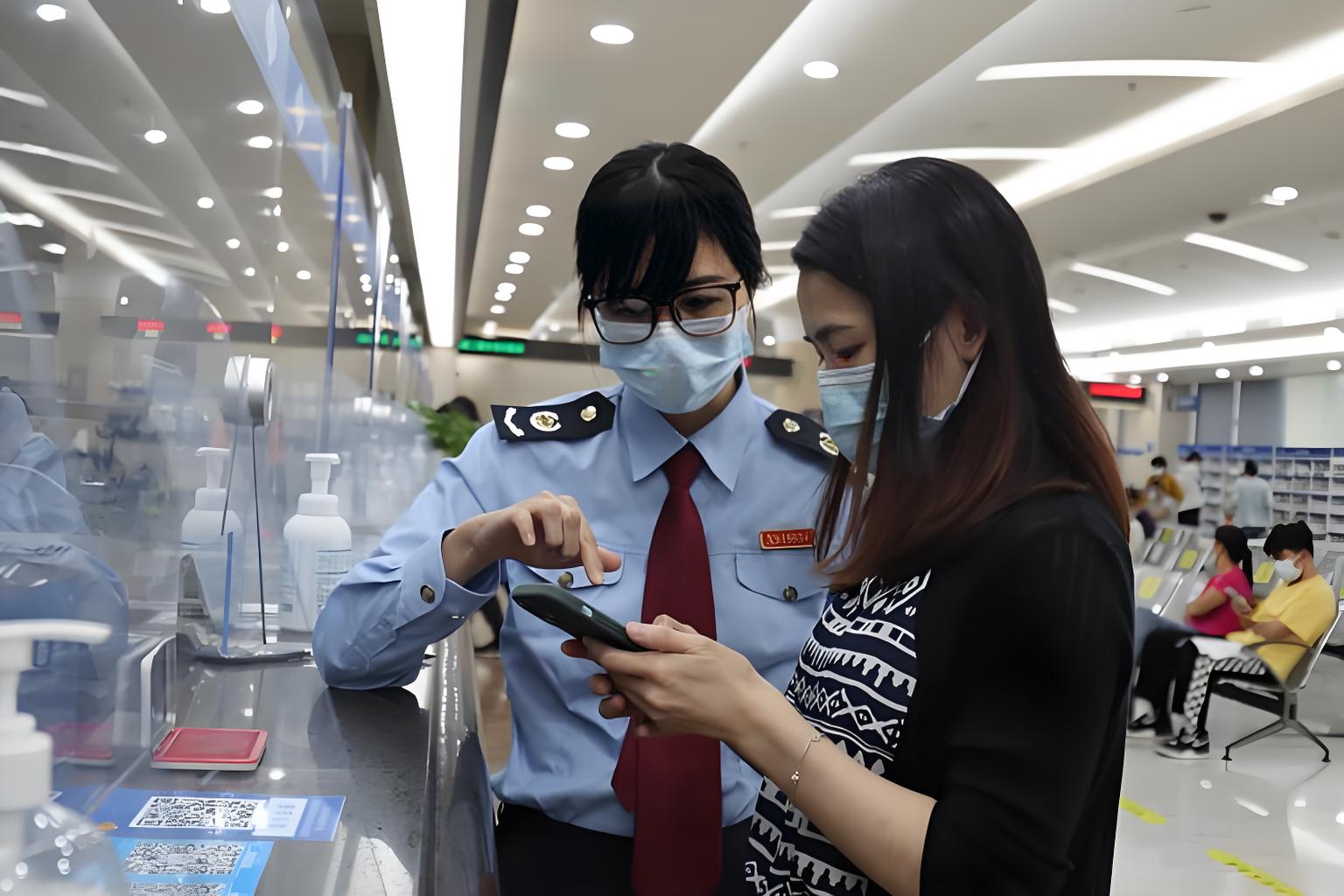 税务局工作人员现场指导办税民众手机操作